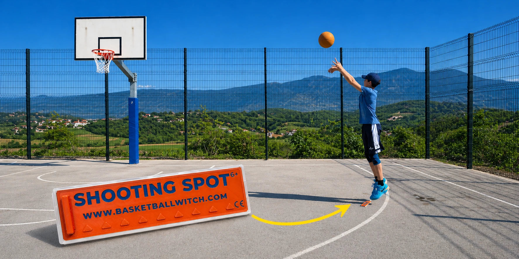 Person playing basketball on an outdoor court with a 'Shooting Spot' sign in the foreground.